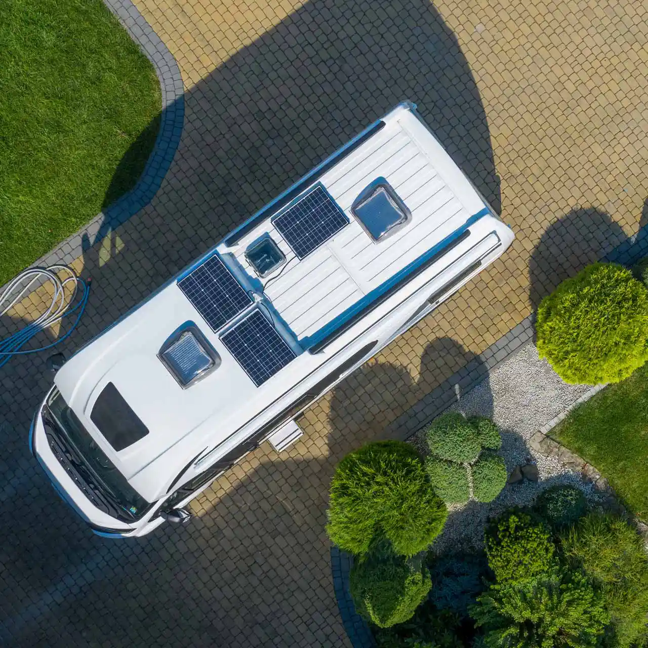 Camper van pulled into an autumn forest with a couple relaxing at the open side door